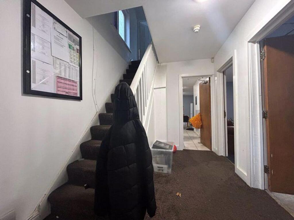 A modest hallway with a staircase, featuring a ...