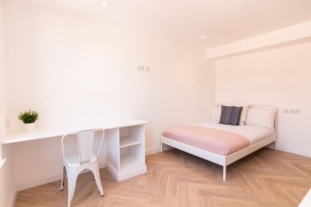 A bright and minimalist single bedroom featurin...