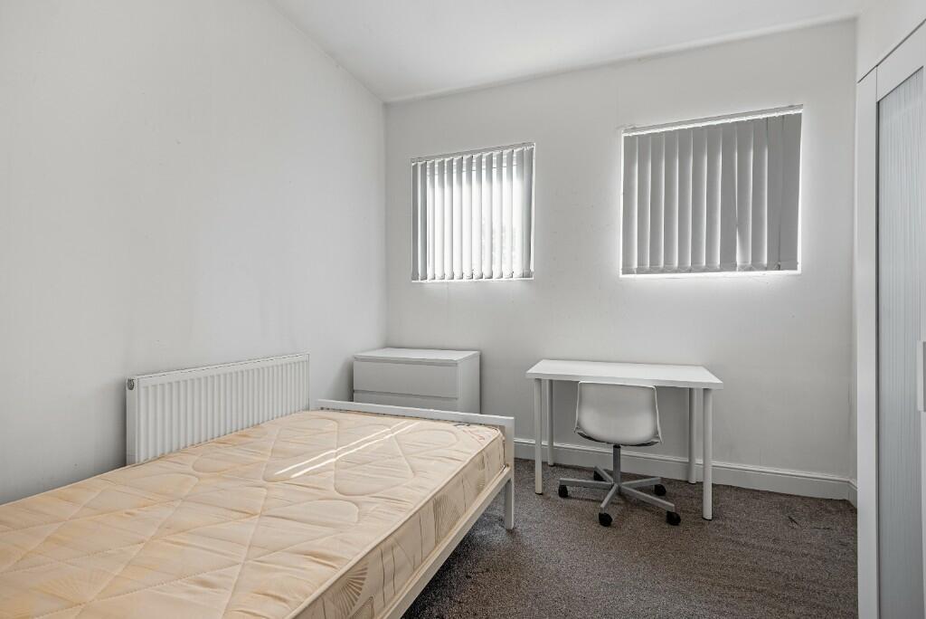 A neat and well-lit single bedroom featuring a ...