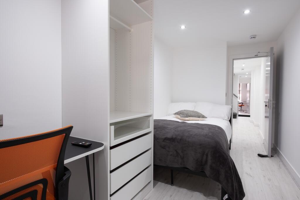 This cozy double bedroom features a comfortable...