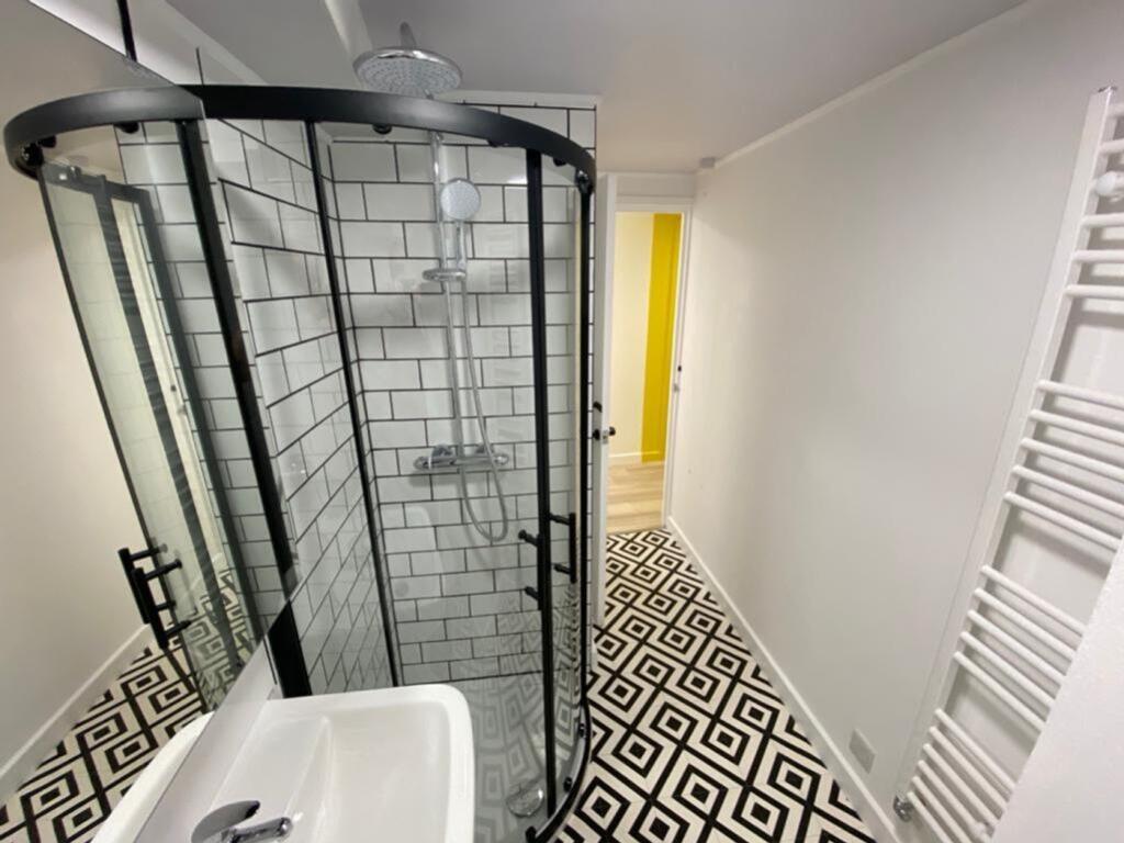 This modern bathroom features a stylish walk-in...