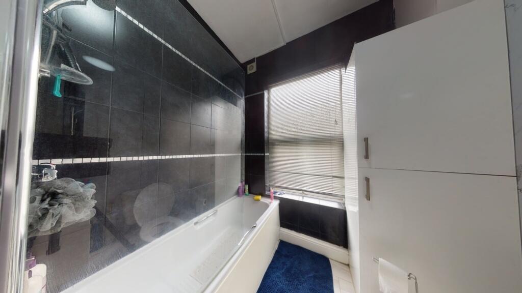 A modern bathroom suite featuring a bathtub wit...