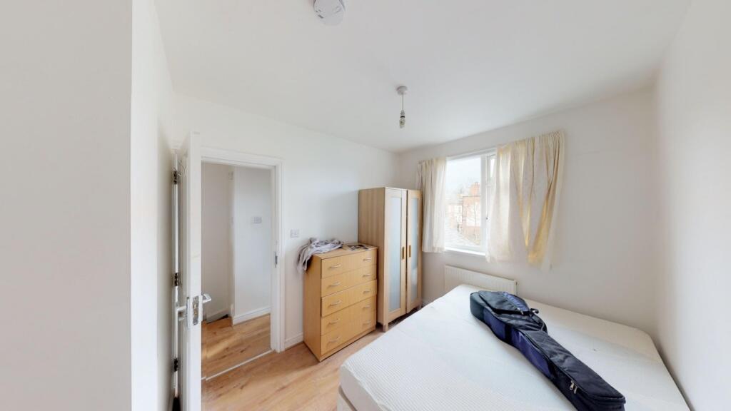 A bright double bedroom featuring a large windo...