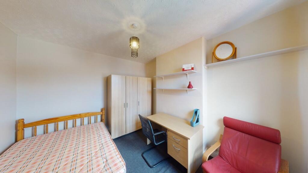 Cozy single bedroom featuring a comfortable bed...