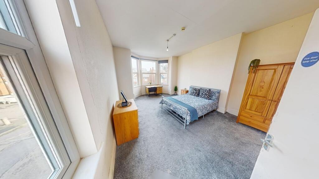 Bright and welcoming double bedroom featuring a...