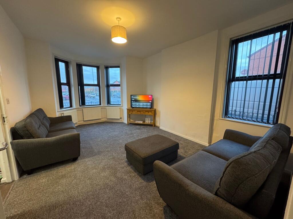 A spacious and tidy living room featuring two c...