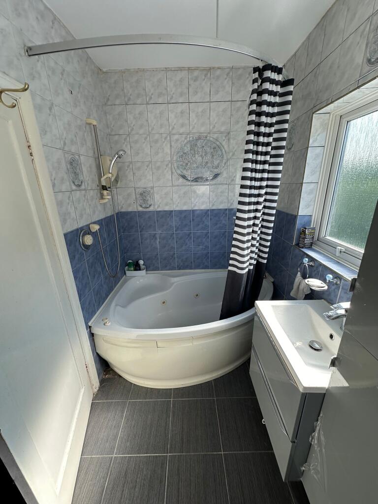 Bright and clean bathroom suite featuring a cor...