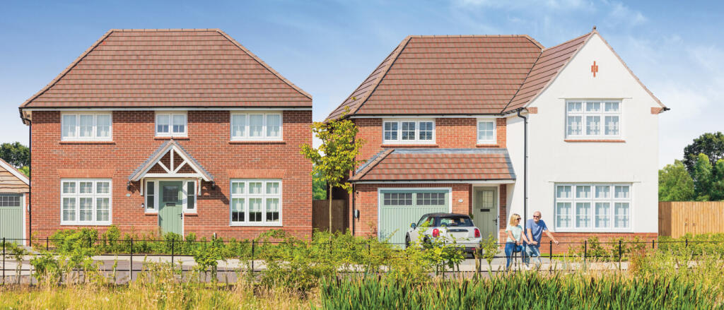 Two modern detached houses with red brick and white facades, front gardens, and a couple walking alo