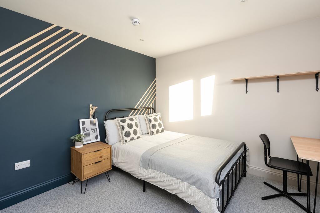 Bright, stylish bedroom with a metal double bed...