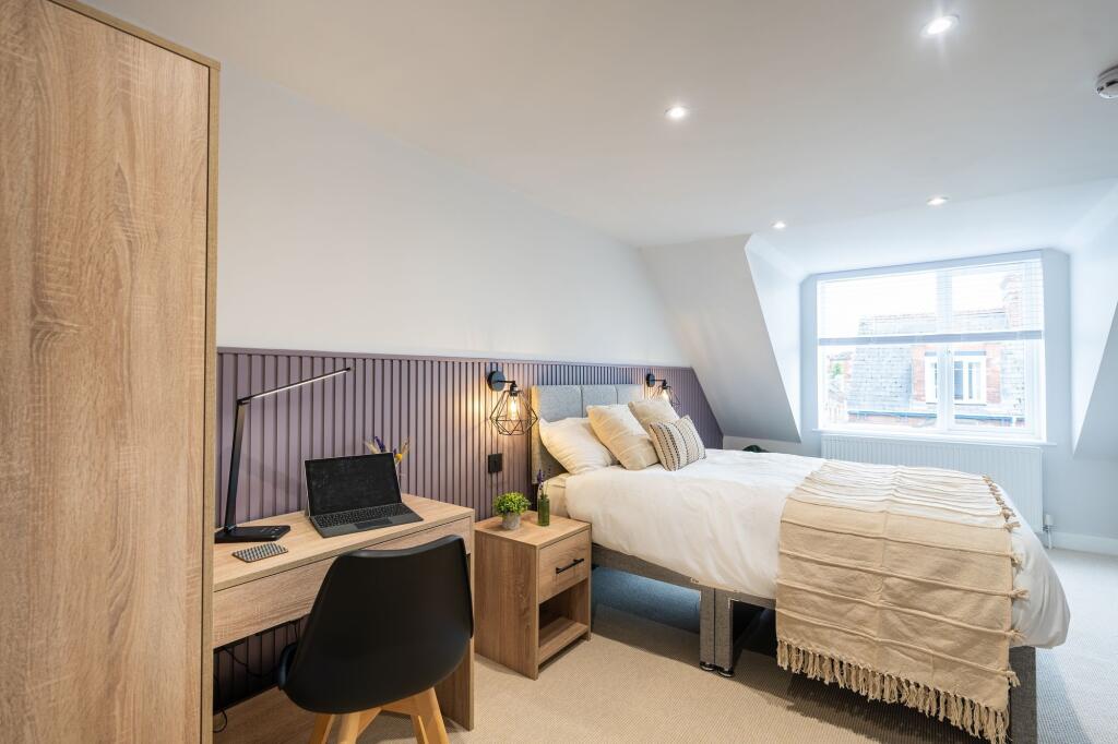 A bright and stylish master bedroom featuring a...