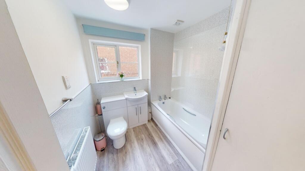 A bright and modern large bathroom featuring a ...