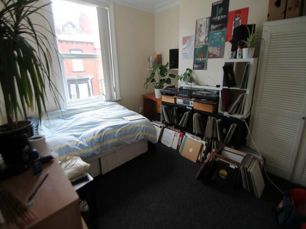 A cozy living space featuring a bed, desk area,...
