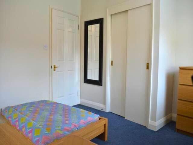 A neat and tidy single bedroom featuring a bed ...