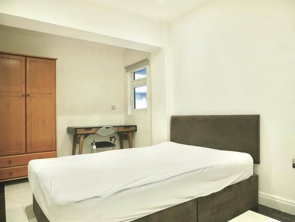 A neat double bedroom featuring a comfortable b...
