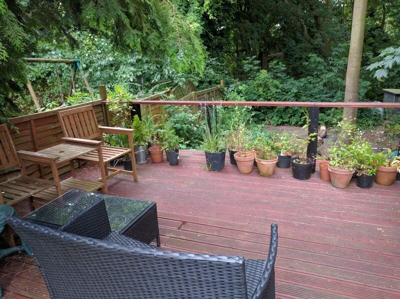 A charming garden deck area featuring comfortab...