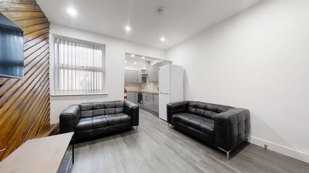 Modern living room with two black sofas, bright...