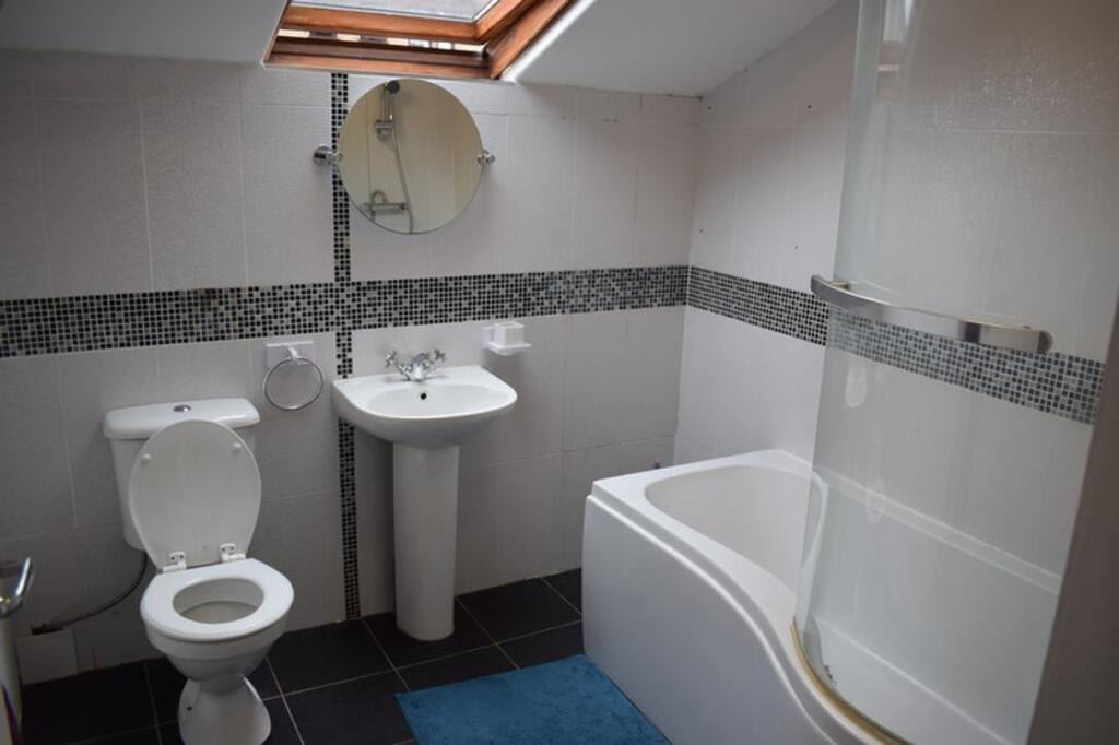 A modern bathroom suite featuring a sleek batht...