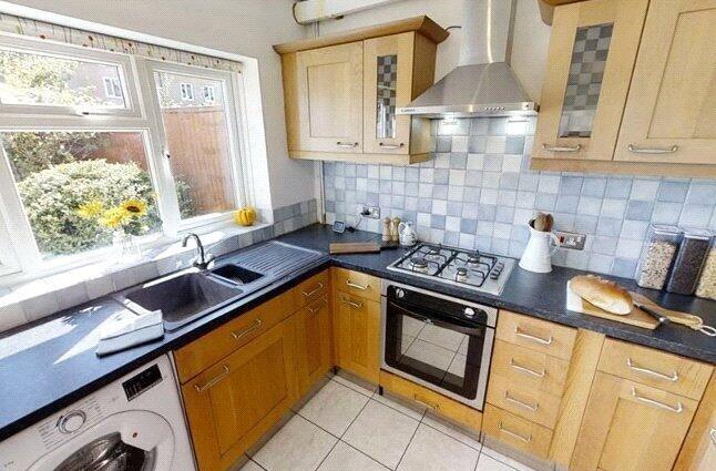 A bright and tidy kitchen featuring ample natur...