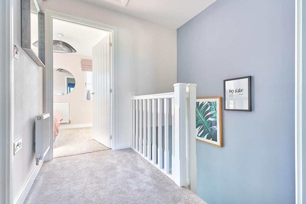The stairs from the living room flow up to the bright landing