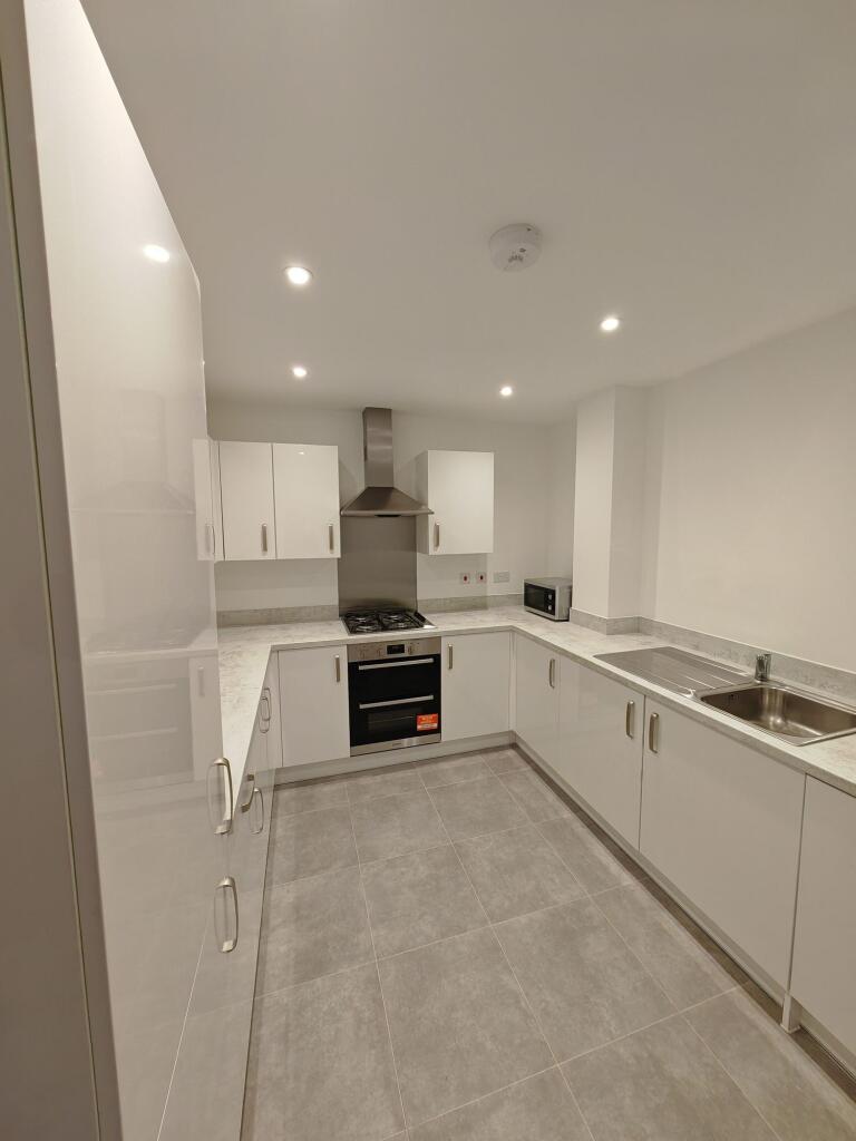 A modern, clean kitchen featuring sleek white c...