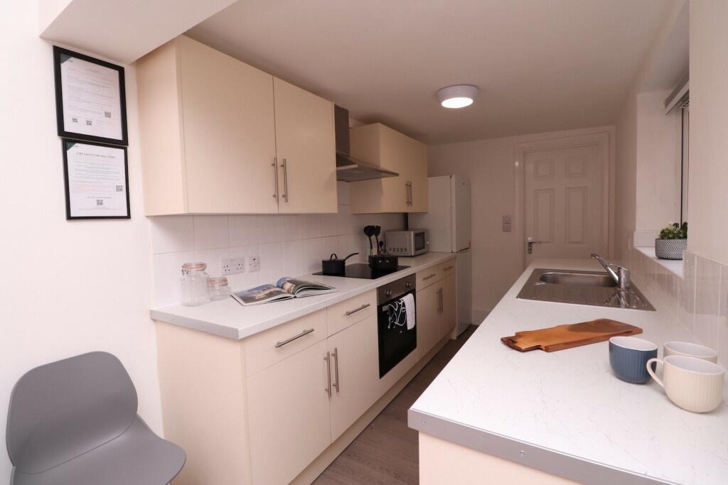 A bright and clean kitchen featuring white cabi...