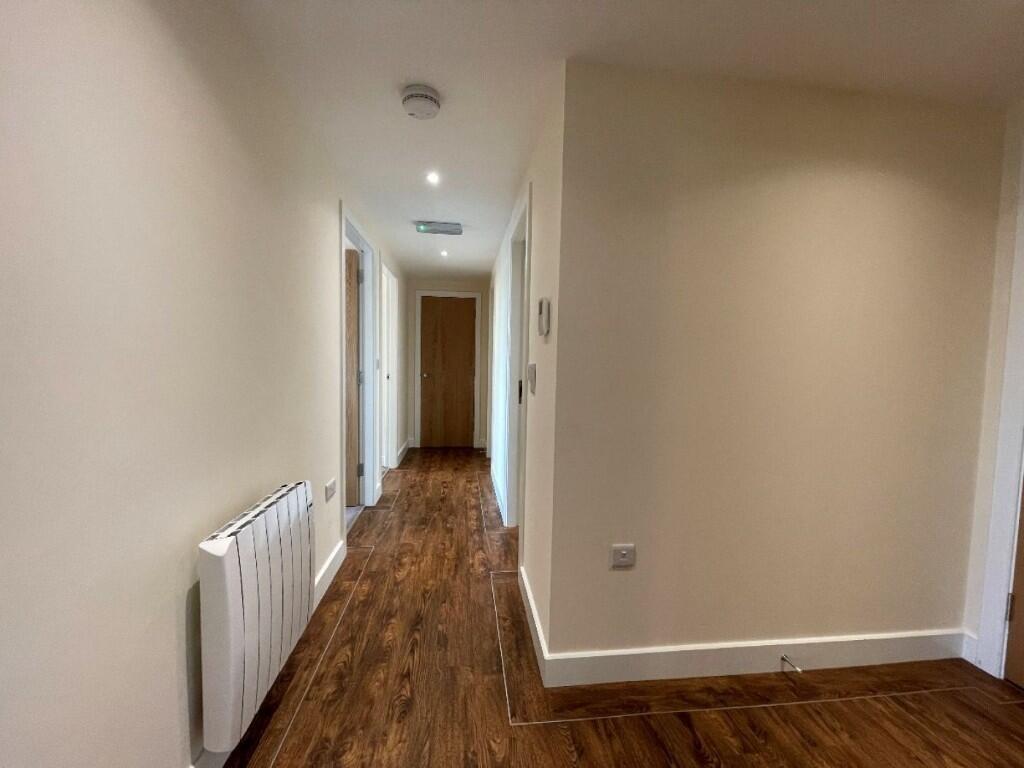 A clean and well-maintained hallway with warm w...