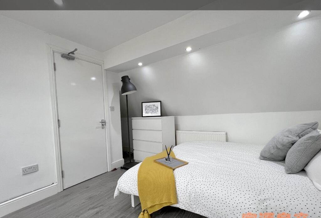 A cozy single bedroom featuring a neatly made b...