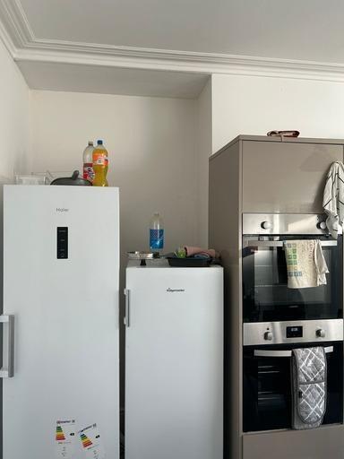 A modern kitchen area featuring a refrigerator,...