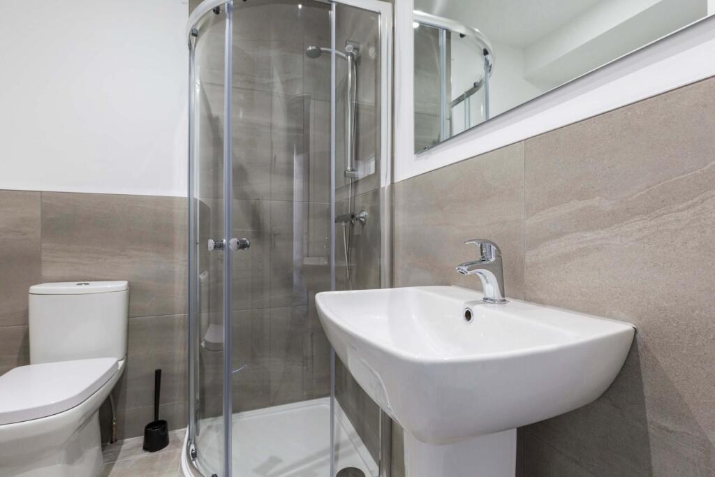 A clean and modern bathroom featuring a shower ...