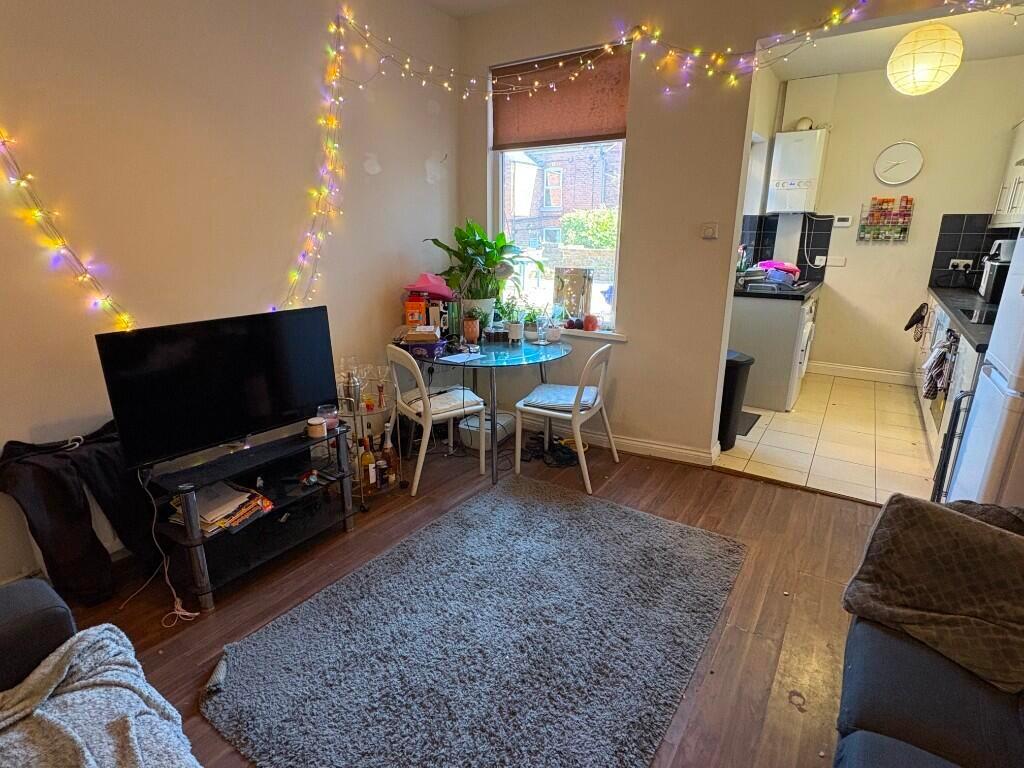 A cozy living room featuring a comfy sofa, a TV...