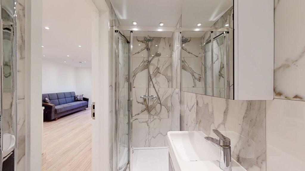 A modern bathroom featuring elegant marble-effe...