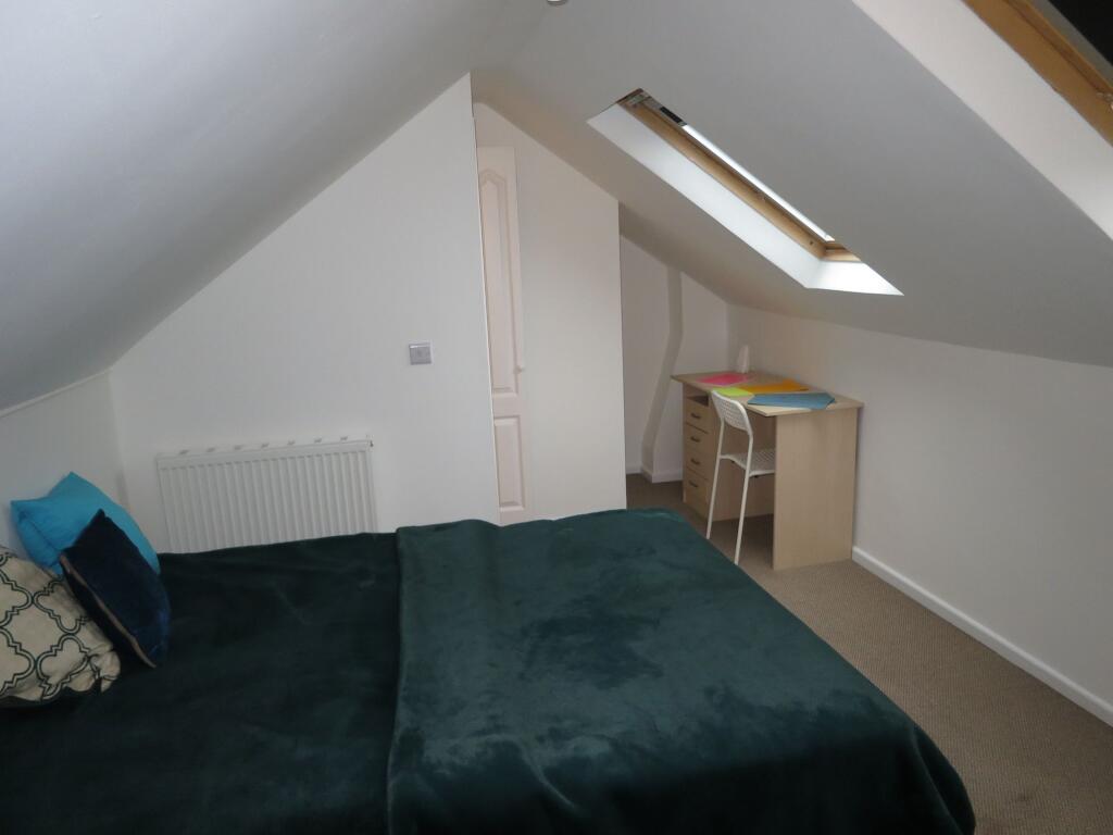 Bright and cozy bedroom featuring a large bed w...