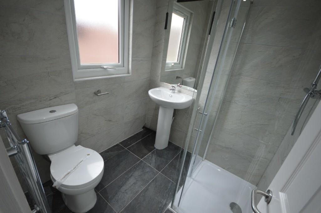 A modern bathroom featuring sleek tiles, a walk...