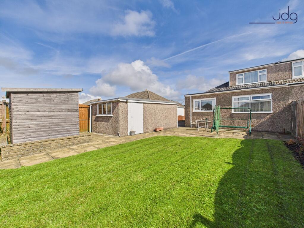 Spacious rear garden with flags and lawn