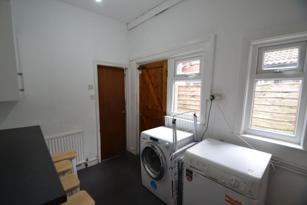 A tidy laundry area featuring a washing machine...