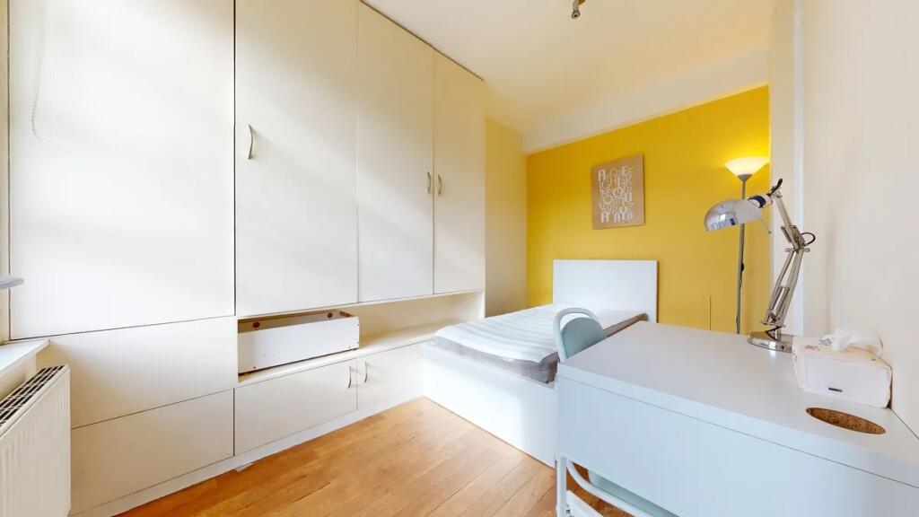 A bright and tidy single bedroom featuring a wh...