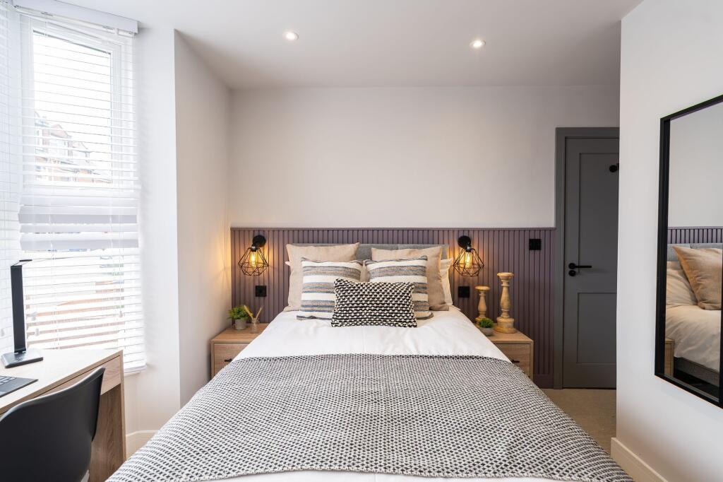 Modern double bedroom featuring a cozy bed with...
