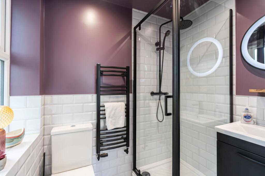 Modern bathroom featuring a walk-in shower with...