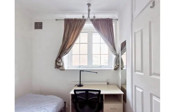 Bright and tidy single bedroom featuring a wind...