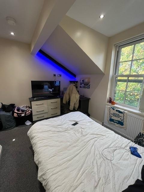 A spacious master bedroom with a comfortable be...