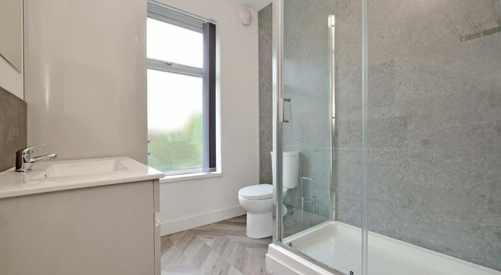 This stylish bathroom features modern fixtures,...