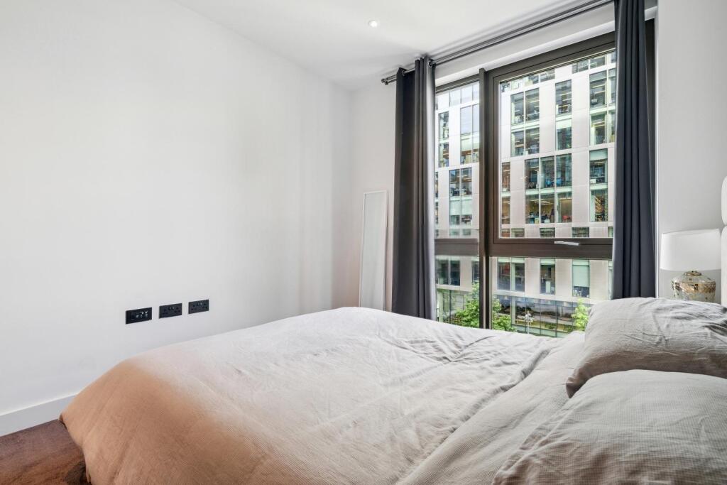 Bright and airy master bedroom with a large win...