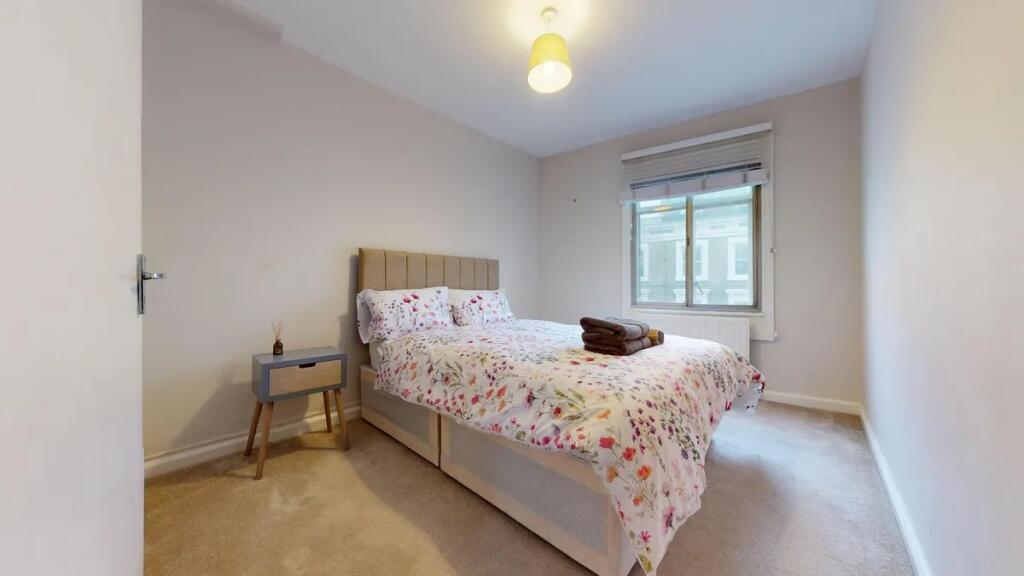 A bright and tidy double bedroom featuring a co...