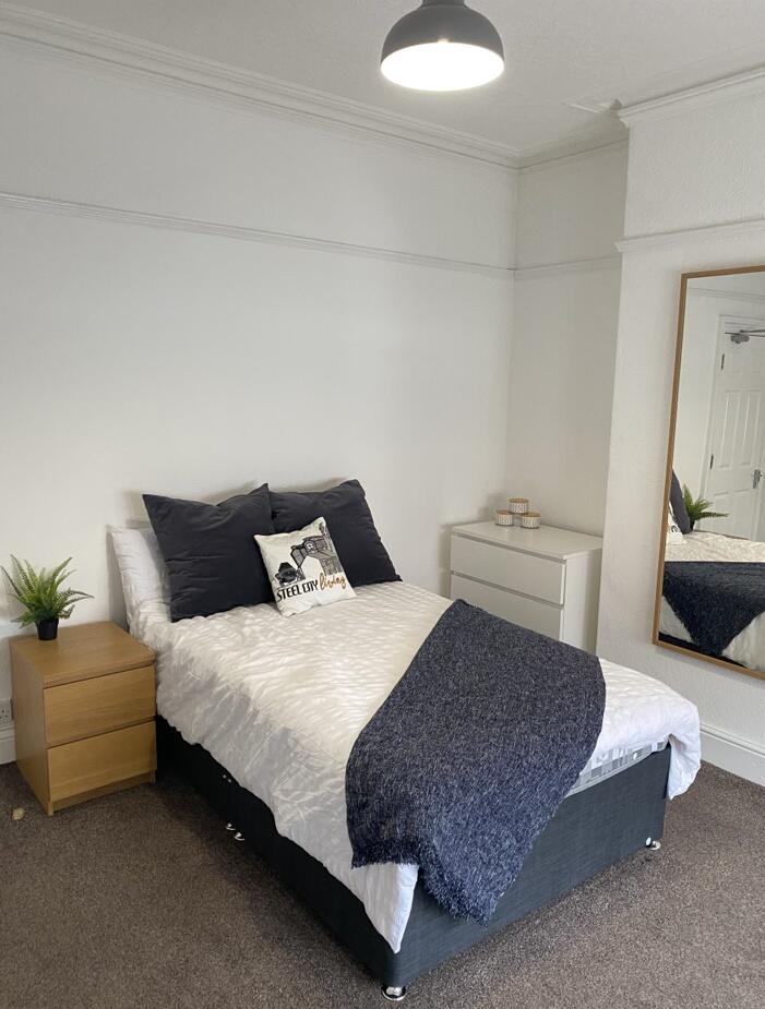 This inviting double bedroom features a cozy be...