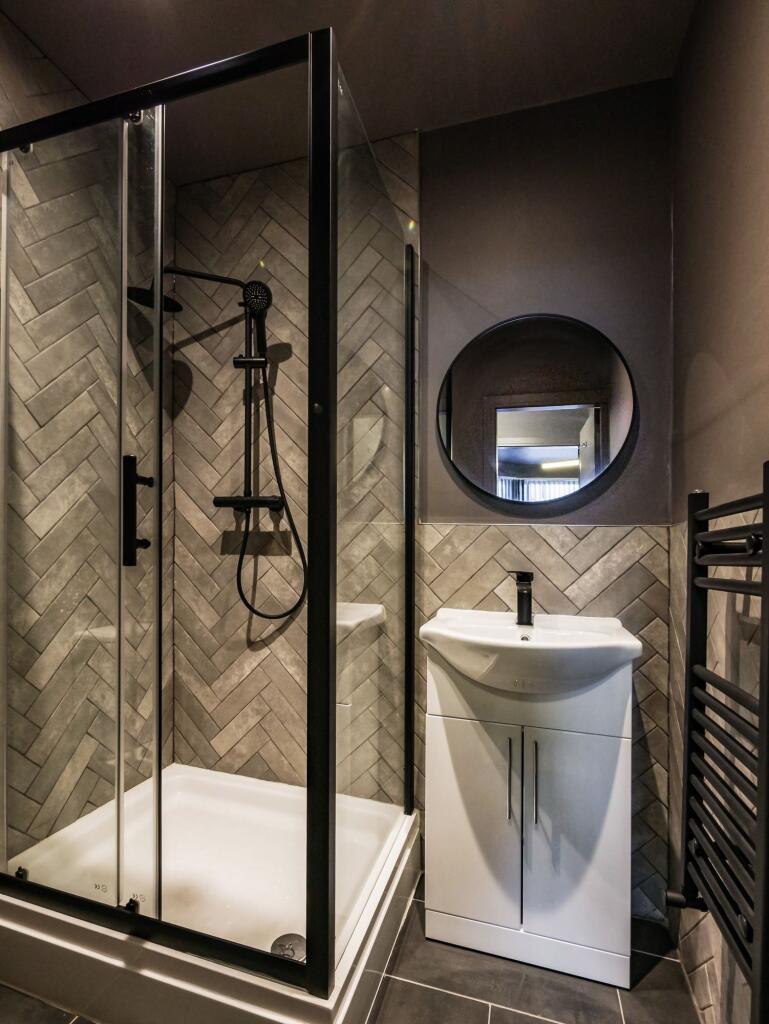 Modern bathroom featuring a sleek black-framed ...