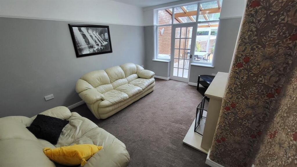 A bright and welcoming living room featuring co...