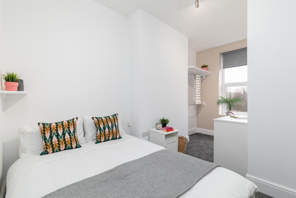 Bright and tidy bedroom featuring a comfortable...