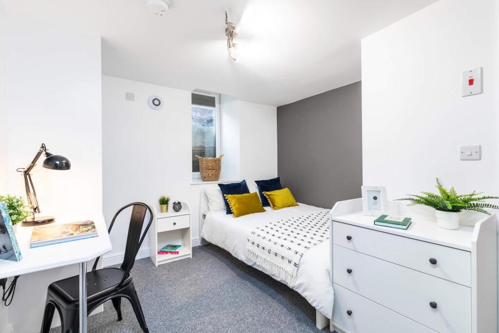 Bright, modern bedroom with a neatly made doubl...