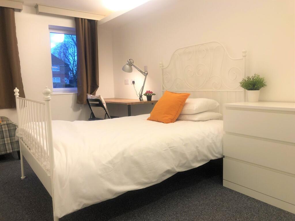 Bright and cozy single bedroom featuring a neat...