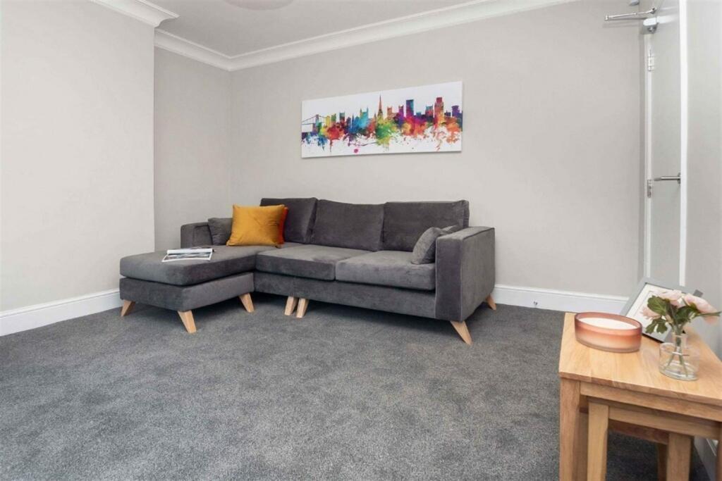 A cozy living room featuring a modern grey sect...